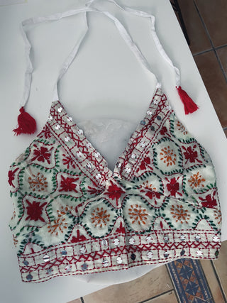 Top Blanco bordado con detalles rojos, verdes y naranjas.